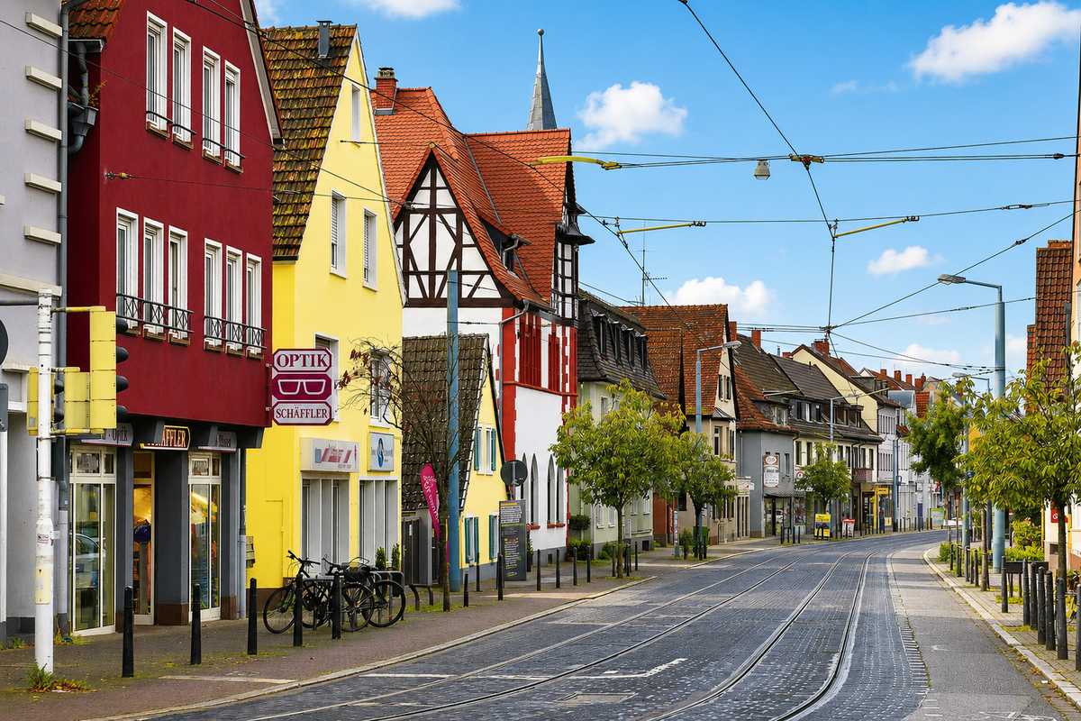 Bunte Altort-Hauptstraße in Mannheim-Feudenheim mit Fachwerk und Kirchturm – Hausverwaltung Feudenheim von Krämer